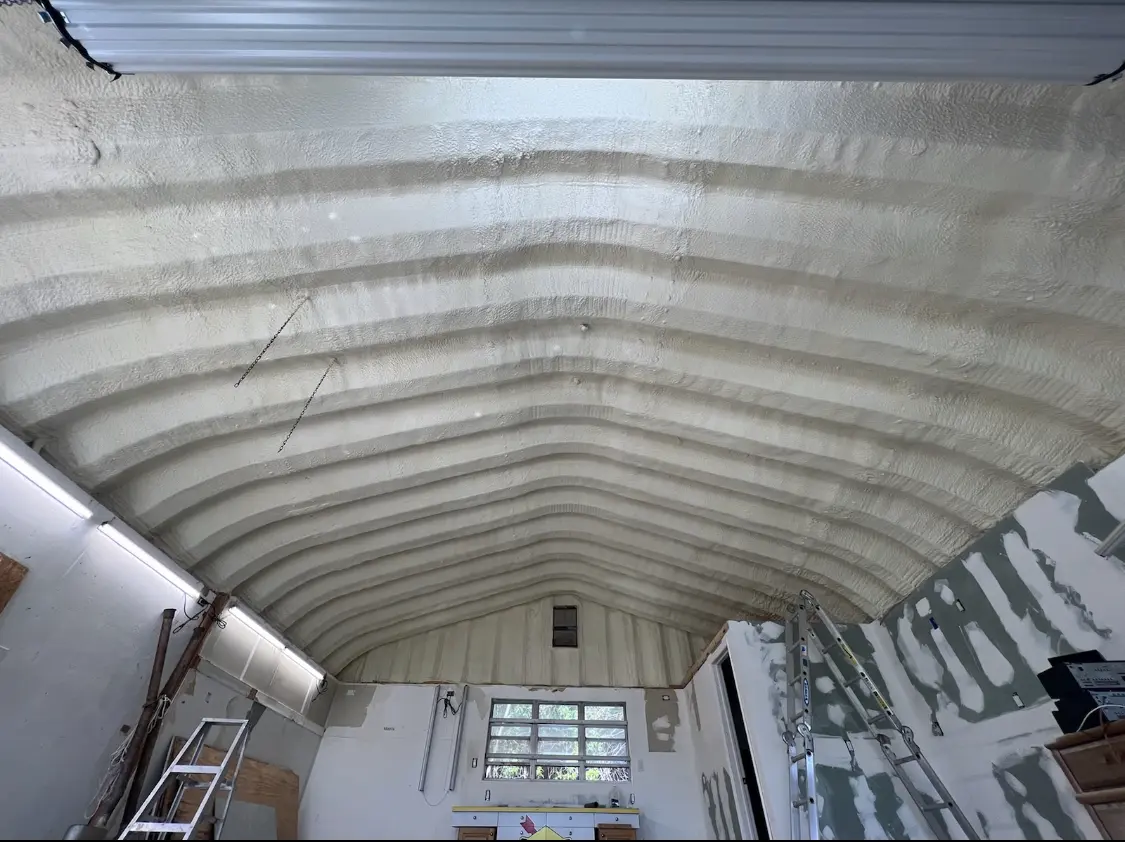 Spray polyurethane foam applied to the underside of a metal roof deck in Kyle